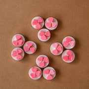 Pink heart-shaped tealight candles arranged on brown background